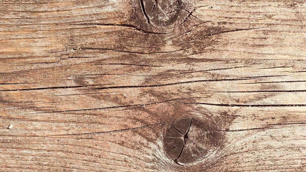 Een foto van hout met twee knoesten en grove nerven.